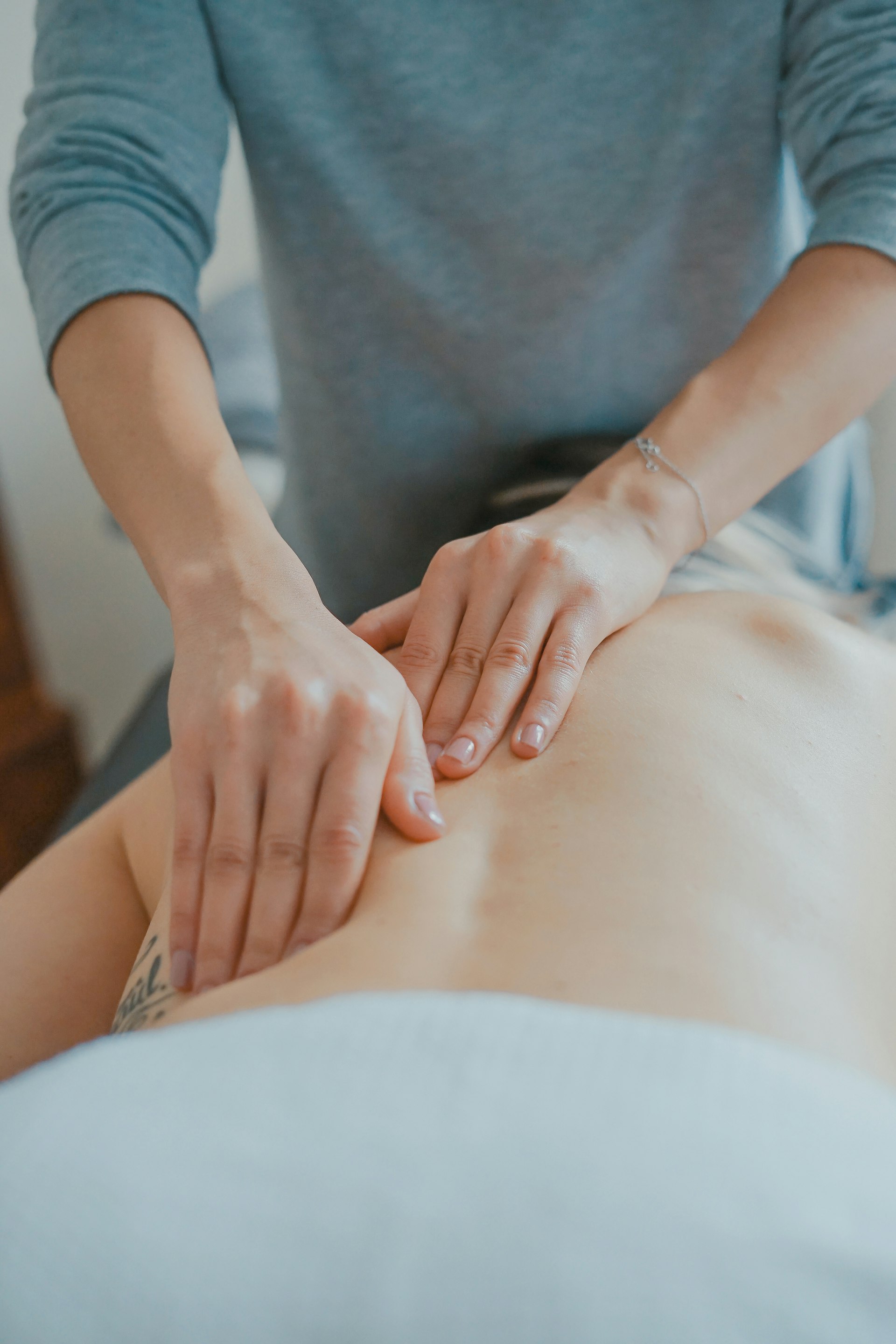 Hot-Stone-Massage mit warmen Steinen auf dem Rücken
